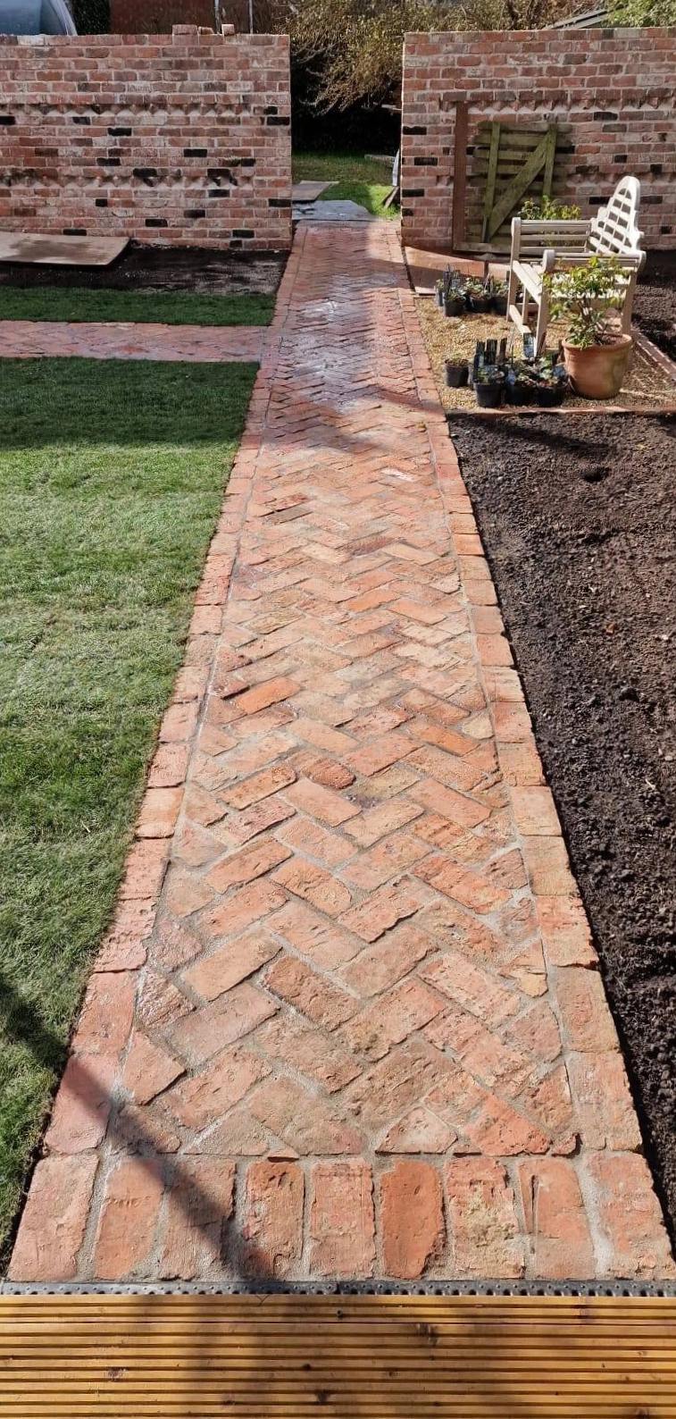 Brick garden path running beside the patio and lawn