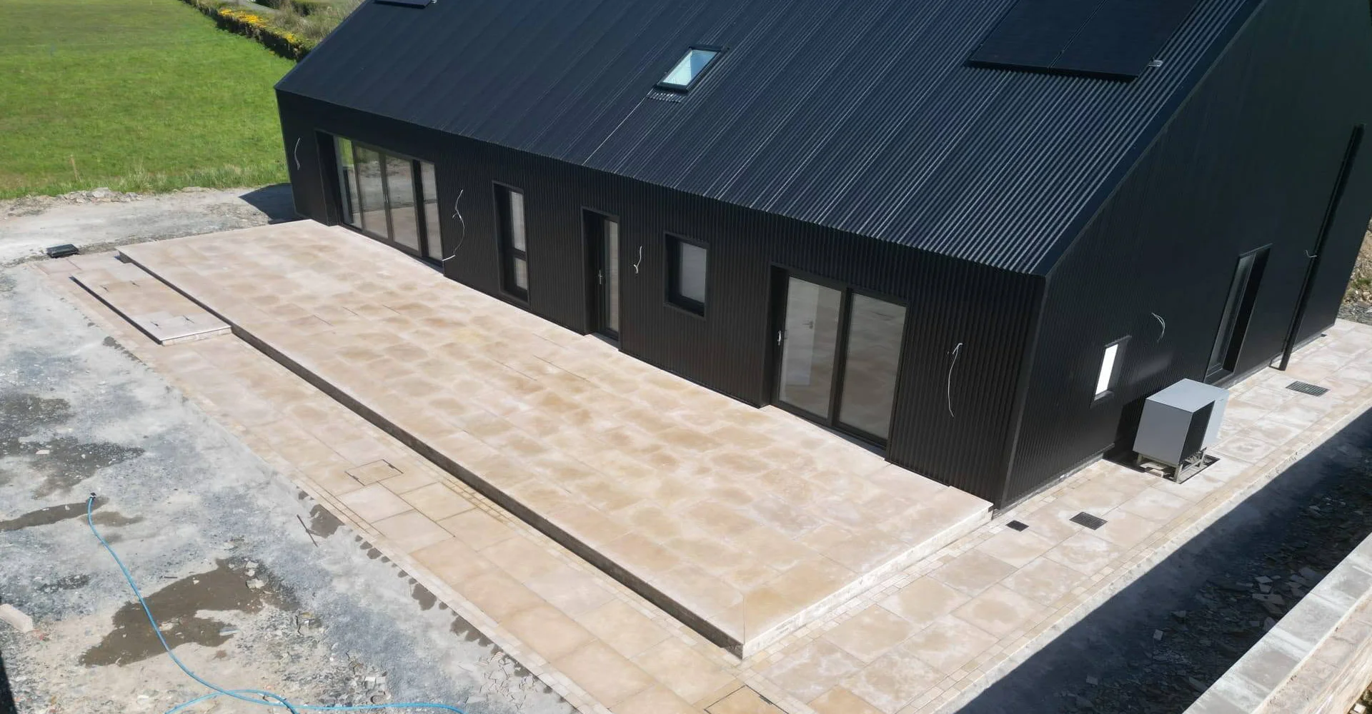 Large paved terrace and wide steps beside a dark-clad building