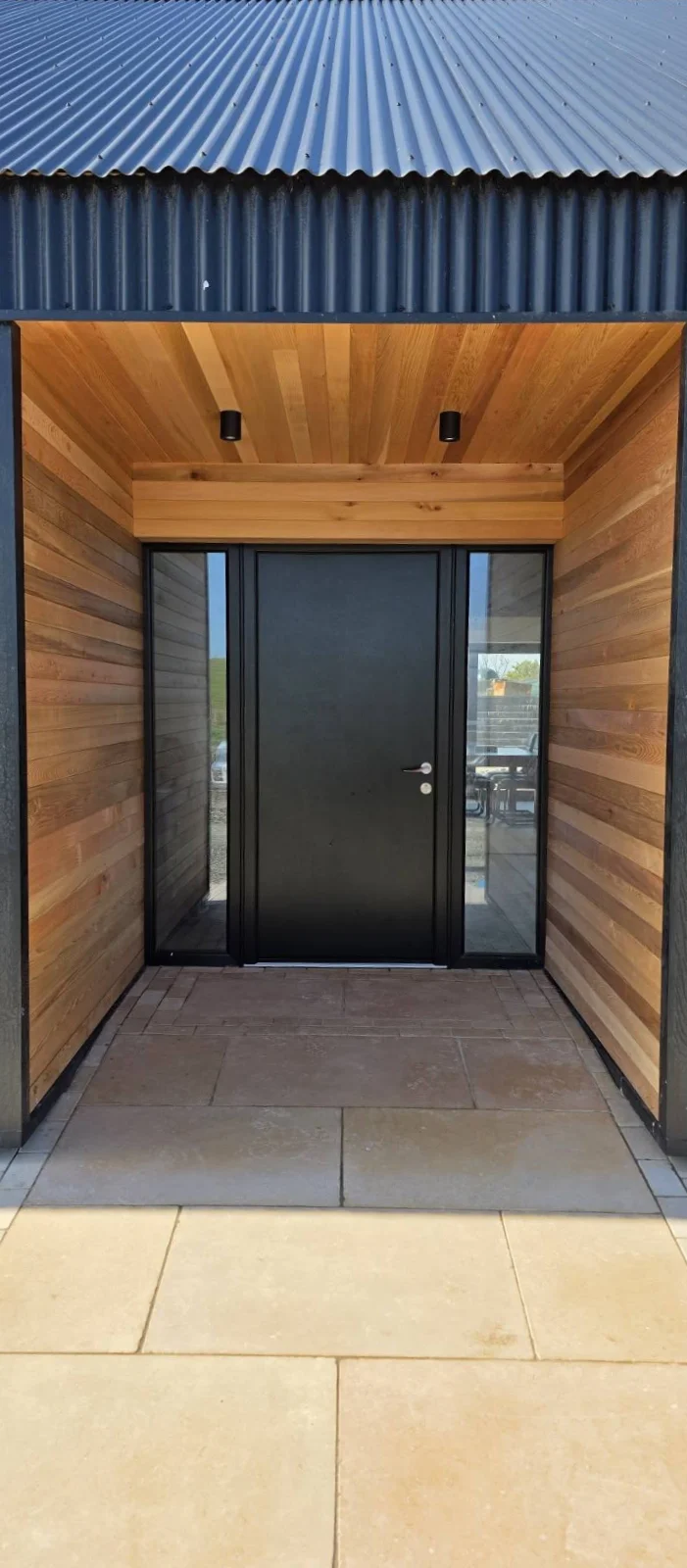 Paved entrance beneath a timber-lined porch