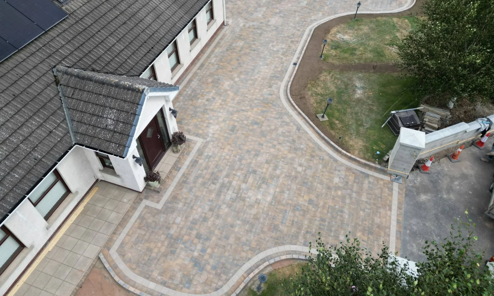 Overhead view of a paved driveway with curved borders beside a lawn