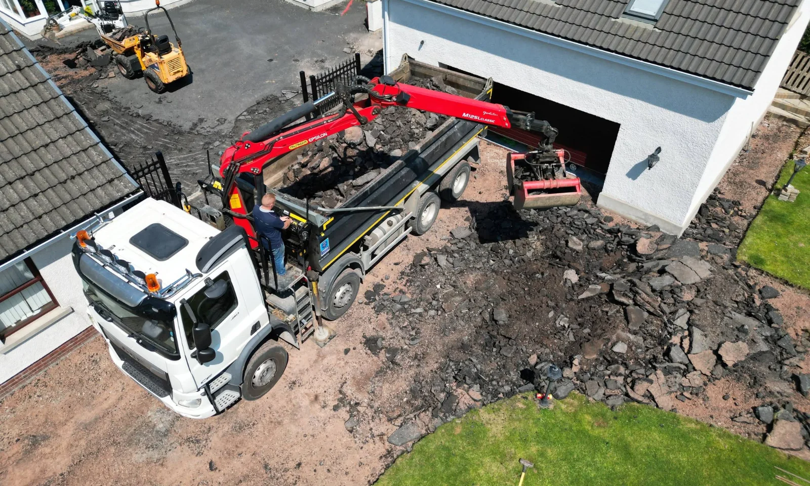Overhead view of excavation work across the driveway