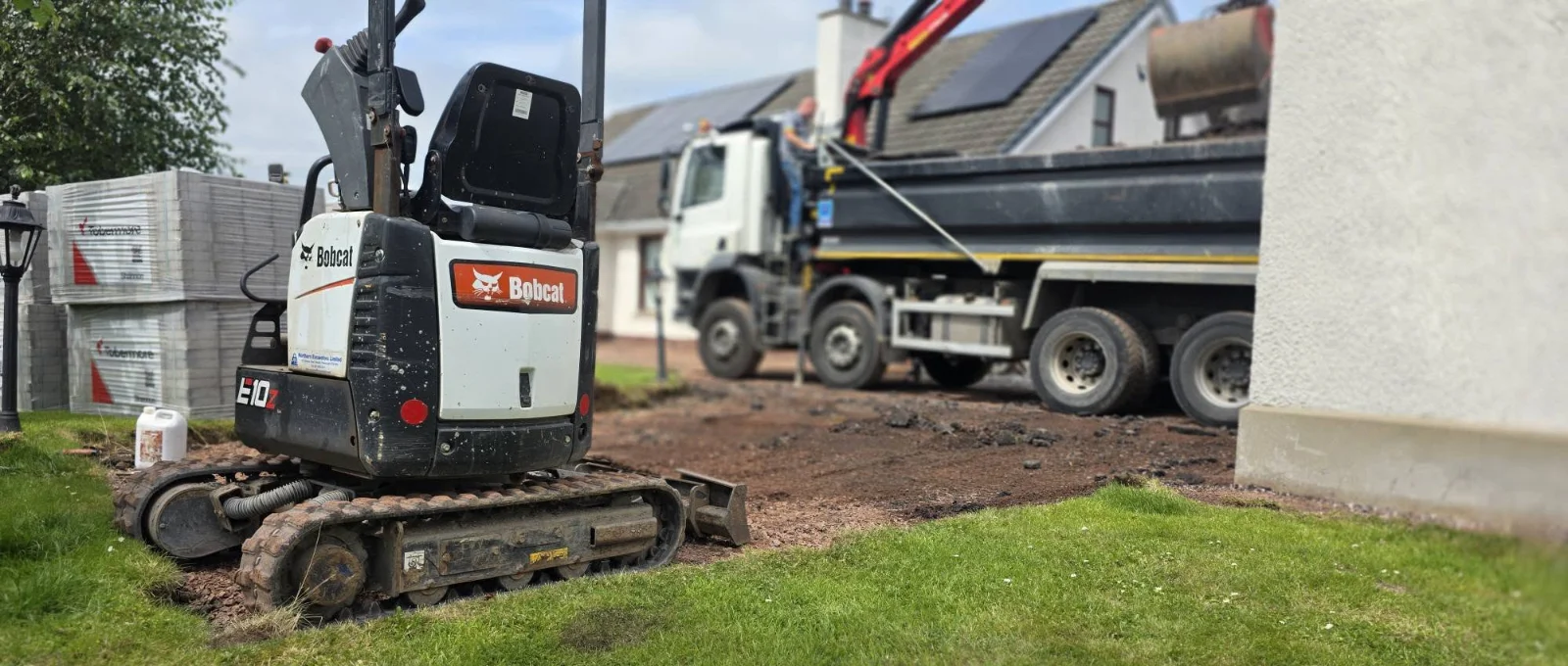 Excavator working beside the curved driveway edge